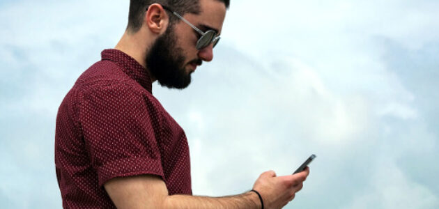 ein Mann schaut aufs Smartphone