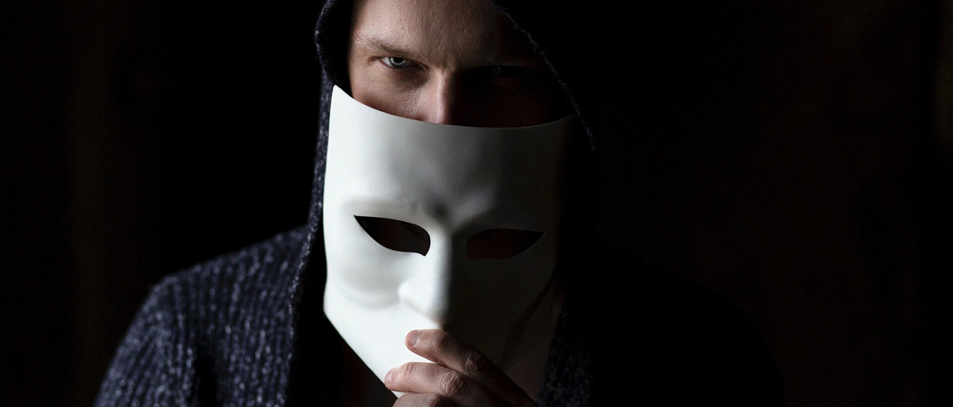 Mann mit Maske vor dem Gesicht als Symbol für Anonymität