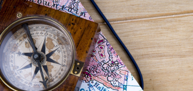 Reiseutensilien Kompass und Karte auf Tisch.