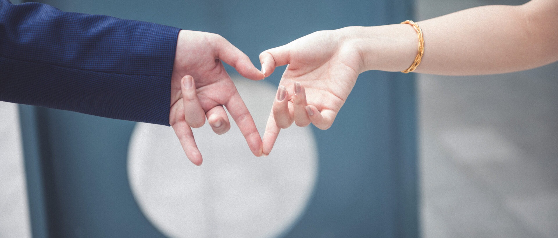 Die Hand einer Frau und eines Mannes formen ein Herz.
