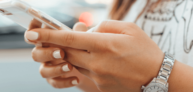 Frauenhände mit Handy sinnbildlich für E-Commerce Shops auf Mobile