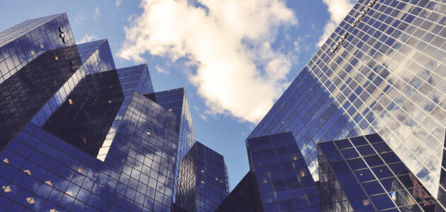 aus der Froschperspektive fotografierte Skyline, in der sich der blaue Himmel und die Wolken spiegeln sinnbildlich für Google My Business und das Tor zur Welt