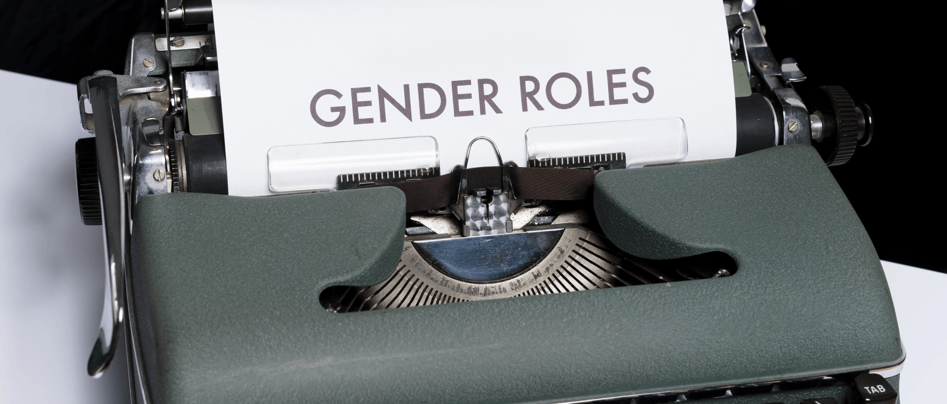 Schreibmaschine mit Papier, auf dem Gender Roles steht sinnbildlich für die Entwicklung der Gender Roles und welchen Einfluss gendertypisches Verhalten auf die Nutzung von Social Media hat xeit