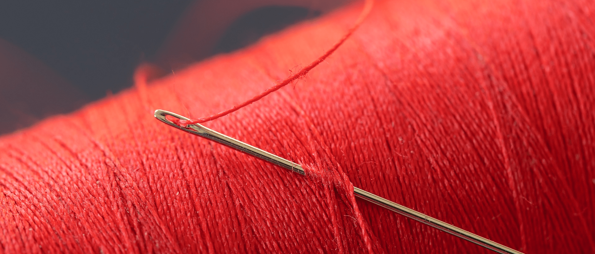 Ein roter Faden mit Nadel steht repräsentativ für den roten Faden im Storytelling