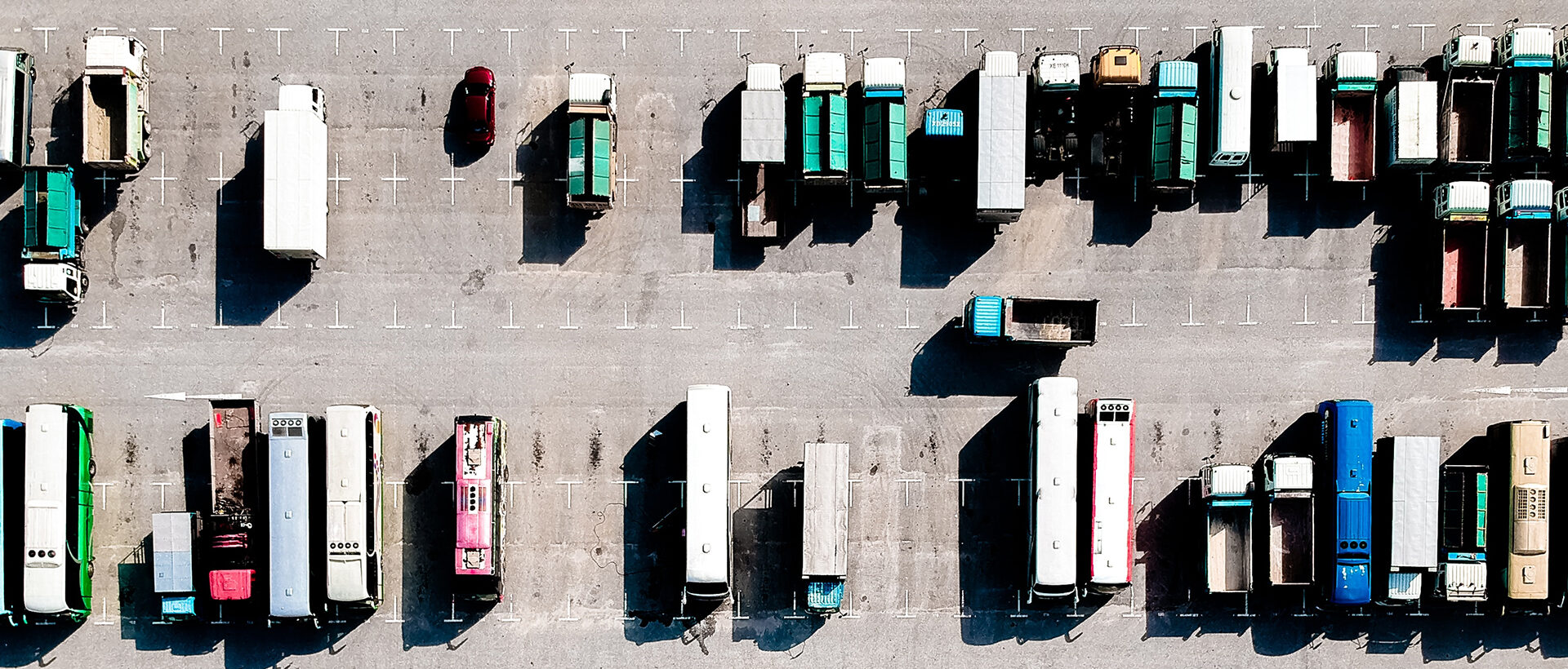 Lastwagen auf einem Parkplatz von oben fotografiert.