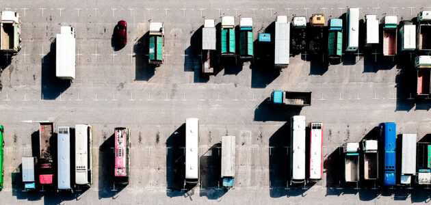 Lastwagen auf einem Parkplatz von oben fotografiert.