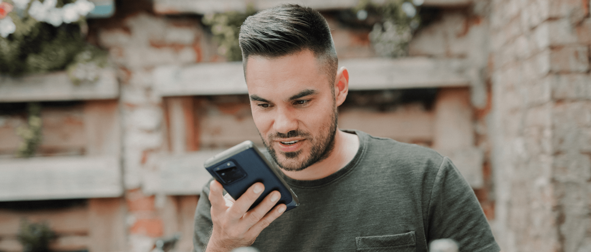Mann nutzt Voice Assistant auf Smartphone