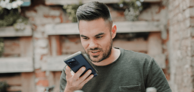 Mann nutzt Voice Assistant auf Smartphone