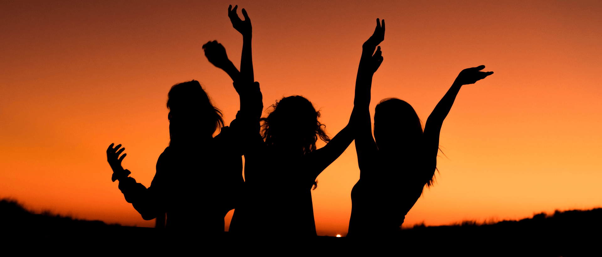 Tanzende Frauen im Sonnenuntergang sinnbildlich für Social Proof und Trust-Elemente auf Websites und Online-Shops xeit