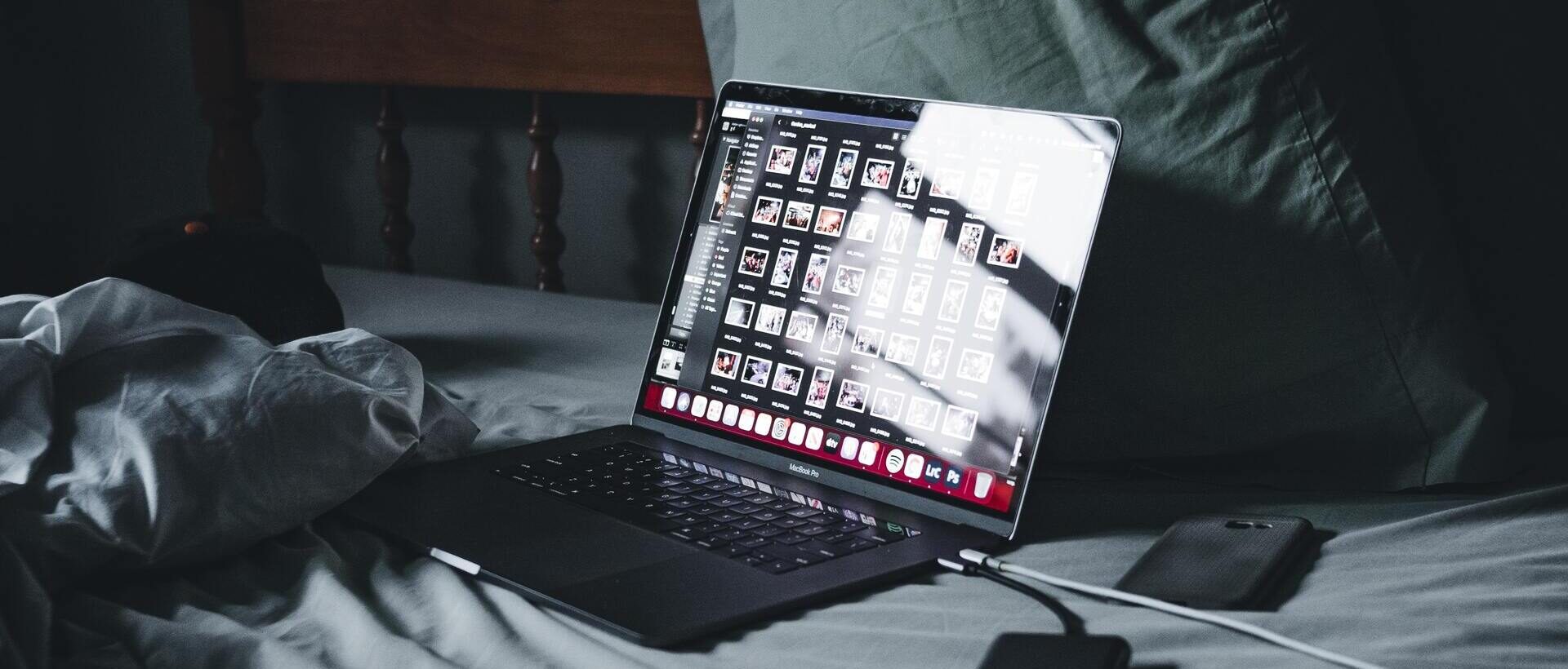 Ein aufgeklappter Laptop auf dem Bett mit einem geöffneten Bildprogramm