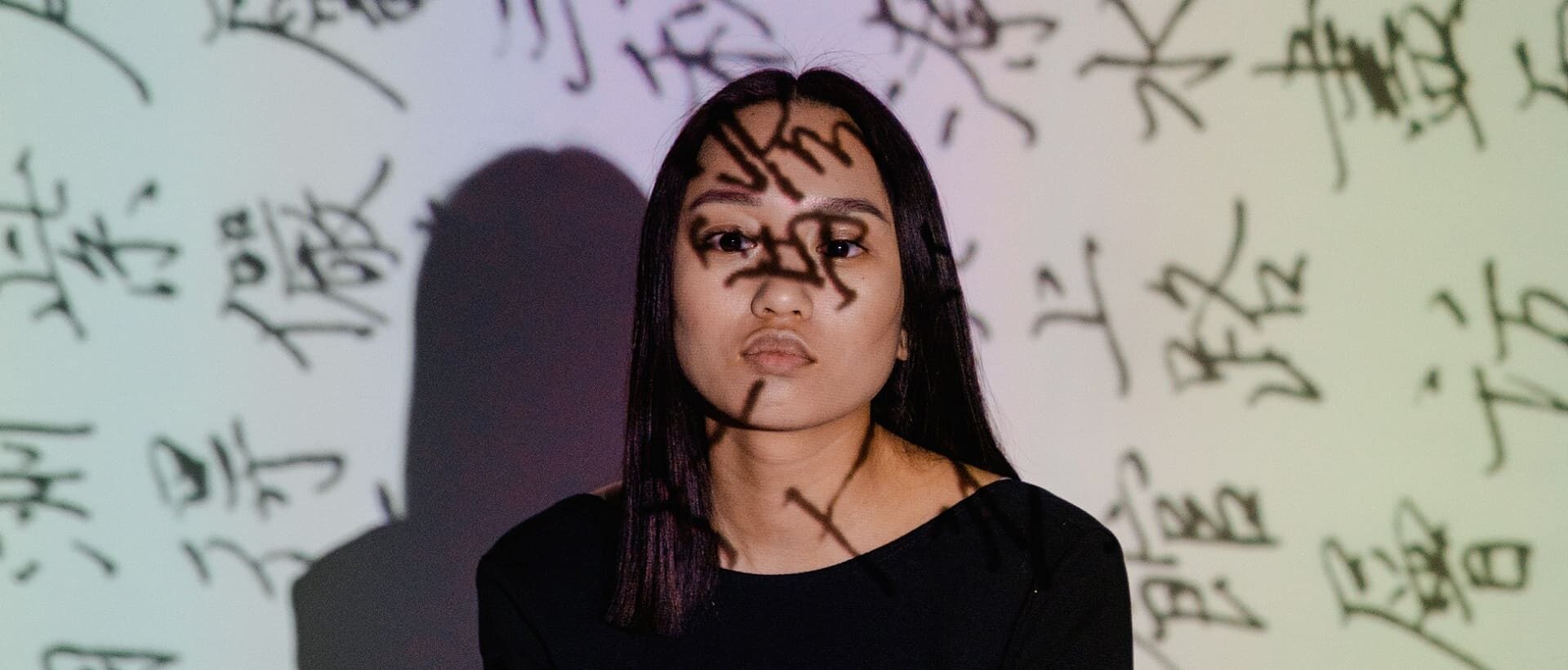 Frau mit Zeichen ins Gesicht projiziert als Symbol für Text auf Bildern im UX Writing