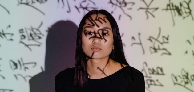 Frau mit Zeichen ins Gesicht projiziert als Symbol für Text auf Bildern im UX Writing