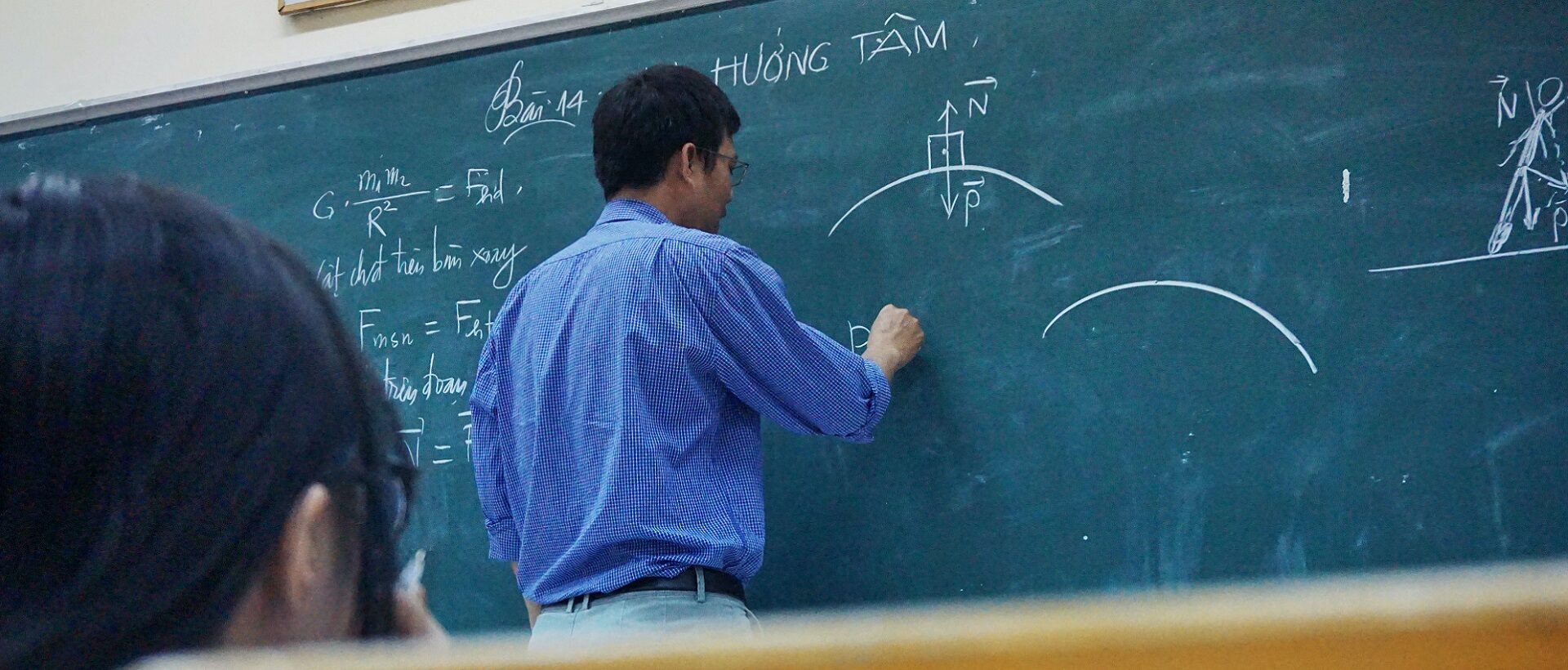 Ein vietnamesischer Lehrer schreibt etwas auf die Wandtafel als Symbol für Strukturierte Daten