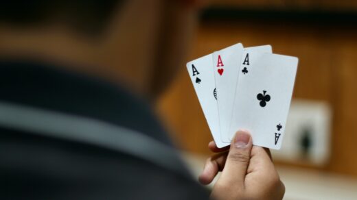 Eine Person hält drei Pokerkarten in der Hand