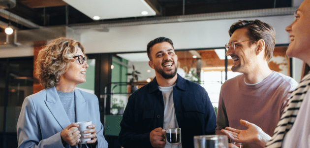 Arbeitskollegen trinken Kaffee und sprechen miteinander.
